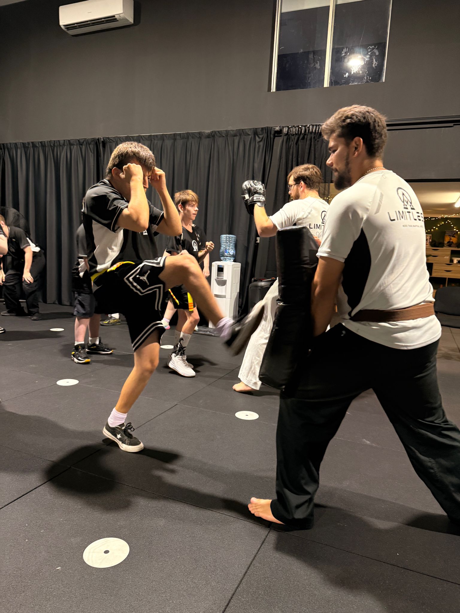 A student practising a kick with instructor support